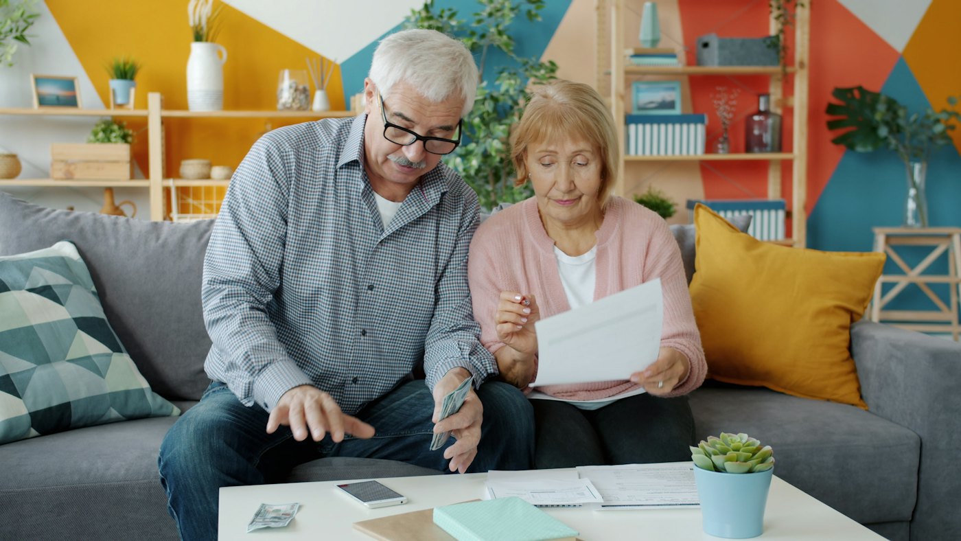 A retired couple reading through documents at home