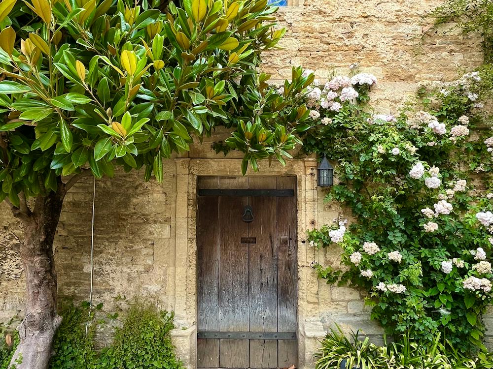 A stone house with roses around the front door